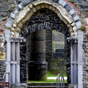 Entrée avec colonnes et voûte travaillée en pierrs dans un mur de briques et de pierres donnant sur une pièce avec colonnes - en ruine - Belgique  - collection de photos clin d'oeil, catégorie rues